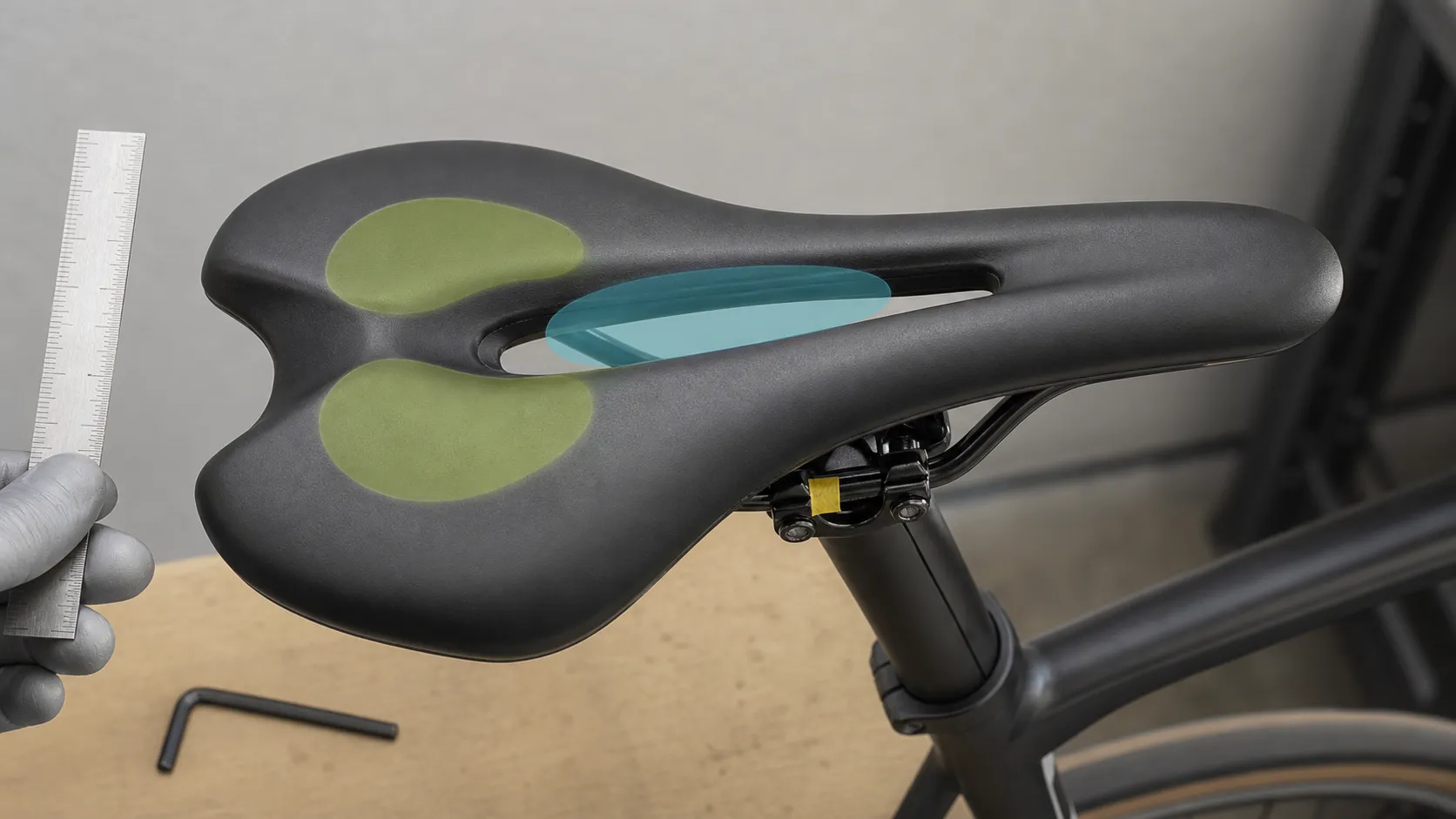 A road-bike saddle with translucent zones showing rear sit-bone support and center pressure-relief area, with saddle rails and clamp visible